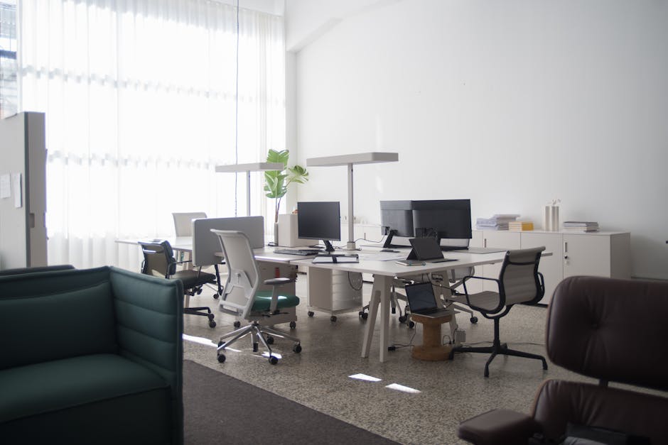 A spacious office interior in Portugal with desks, chairs, and computers under natural light