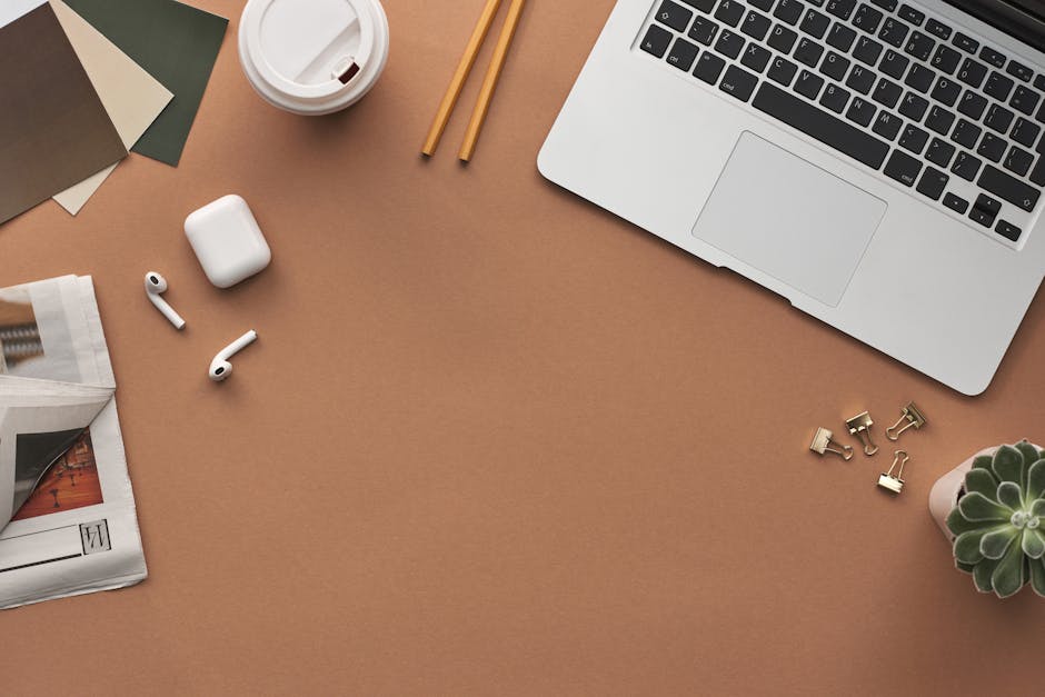 Flat lay of a modern workspace with a laptop, AirPods, and coffee for productivity